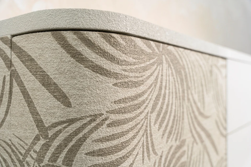 Dettaglio curvo del mobile con finitura Woodress naturale e decorazione botanica